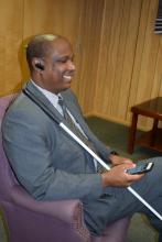 Anil Lewis Executive Director of the Jernigan Institute using his smartphone to read NFB-NEWSLINE